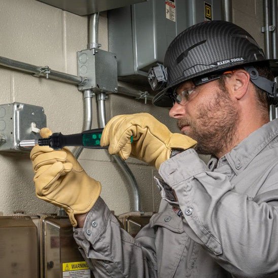 Homme assemble avec tournevis un interrupteur mécanique